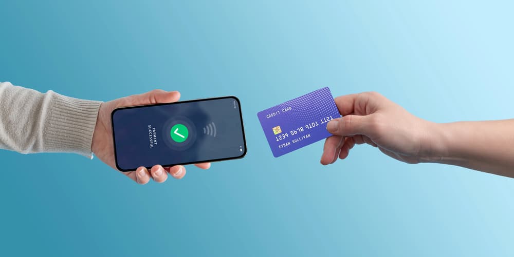 One hand holding a phone that reads payment successful while another taps a card against it